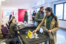 910724 Afbeelding van iemand die een stem uitbreng tijdens de Gemeenteraadsverkiezingen van Utrecht en het Referendum ...